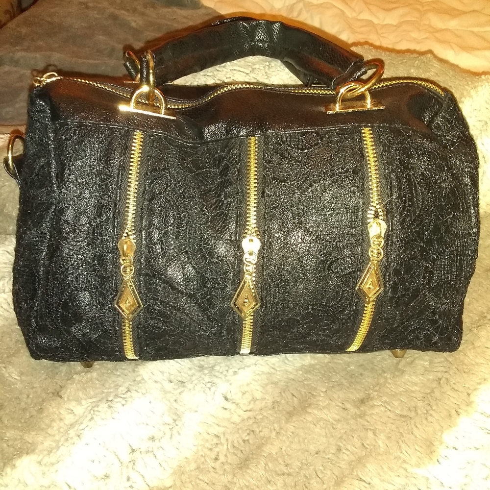 Black satchel with lace detailing and gold hardwar